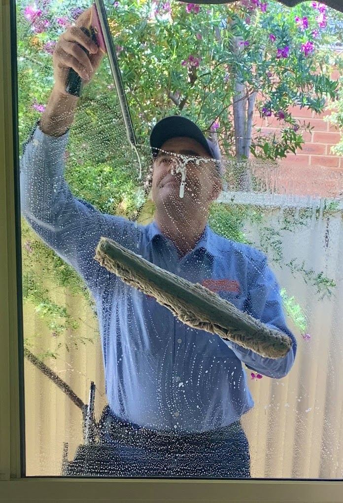 Sparkles technician hand-cleaning a window